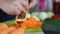 A man grinds carrots on a grater. Nearby vegetables for cooking squash caviar. Zucchini, carrots, onions and tomatoes on the table