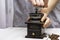 Man grinds coffee beans in a manual coffee grinder