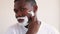 Man grooming confident black guy shaving razor