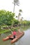 A man guiding a canoe boat on a small stream at the Polynesian Cultural Center