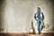 Man and guitar against a grungy wall in hdr