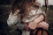 man with guitar hugging his boho gypsy woman closeup in windy field. atmospheric sensual moment. stylish hipster couple in