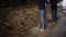 Man in gumboots walking along cowshed on farm