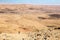 Man guy tourist backpacker standing looking view desert mountain slope