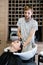 Man hairdresser washing head client. A man hair master watering a girl`s hair with a shower in a hair studio.