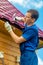 A man with a hammer and a nail repairs the roof of a house