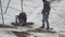 A man hammering a frozen ground with a jackhammer