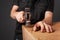 A man hammers nails into a cupboard. The back wall of the cupboard is made of thick cardboard