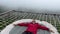 Man on hammock net lying and resting looking into stormy sky in the mountains. High above cloudy abyss. Thick white fog