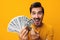 Man hand cash rich finance money currency background happy dollar smiling surprised yellow business