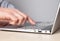 Man hand closeup pressing enter key. Man sitting at table and working on laptop.