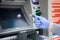 Man hand disposable protective glove holding Visa credit card ATM