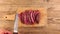 Man hand get hunters knife through sliced grilled medium rare roast beef