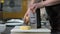 Man hand grating yellow cheese with a metal grater