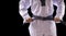 man hand hold black-belt on black background for advertising. The karate man standing with black belt