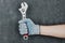 Man hand holding an adjustable spanner wrench on gray background