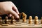 man hand holding black against white knight chess pieces on chess board