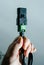 Man hand holding black and green IEC power cable against blue