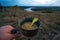 Man hand holding a bowl. Tourist cauldron. Dinner on the hike overlooking the mountains. Evening. Instant macaroni, tourism