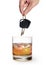 Man hand holding car keys over glass of whiskey isolated on white