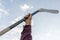 man hand holding a hockey stick against the sky, abstract sport equipments