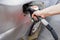 A man hand holding pump filling gasoline. Pumping petrol into the tank.