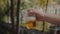 Man Hand Holding And Slow Shaking A Transparent Plastic Cup With Light Beer