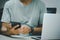 Man hand holding smartphone and computer laptop to working technology searching internet, sending sms, using text messenger or