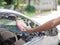 Man hand holding a sponge rubbing the car with foam. Carwash con