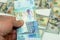 man hand holding a stack of 20 twenty Kuwaiti dinars banknotes money, spending, giving and using money concept, paying and buying