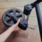 A man hand holds a broken wheel of a baby carriage. Damage and repair of the wheels of the metal frame of the stroller