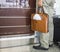 Man hand holds leather bag standing in front of airport check-in desk. Concept of tourism via aviation