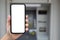 man hand holds phone with  screen background of ATM
