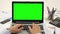 Man hand on laptop keyboard with green screen