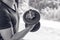 Man hand lifting the steel dumbbell in a gym muscle-building black and white image, life and fitness concept with copy space