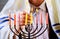 man hand lighting candles in menorah table served for Hanukkah