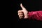 Man hand makes thumb up gesture isolated on black background with copy space for your text