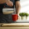 Man hand making tea, poring water into mug.