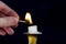 Man hand with Matchstick light flame on candle in candlestick