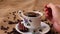 Man hand mixes coffee in a cup with a small metal spoon