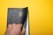 Man hand opening Santa Biblia Holy Bible in spanish on yellow