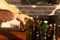 Man hand opens Brown and green ice cold beer bottles with water drops with old opener, closeup