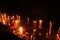 Man Hand Placing Lit Candle into the Votive Candle Stand inside the Church