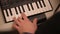 Man hand playing a MIDI controller keyboard synthesizer.