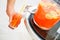 Man hand pouring fresh sorbet fruit juice or alcohol punch from drinking tank machine at party