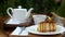 Man hand pouring hot tea in tea cup. Piece of delicious fresh cake in cafe