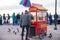 Man hand pushing red popcorn car next to the beach