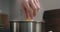 Man hand put fettuccine pasta in saucepan with boiling water