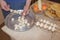 Man hand put raw mushrooms and courgette vegetable pieces on skewer