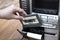 Man hand putting cassette into old fashioned audio tape player on desk wood background